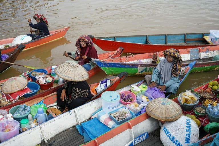 Colorful scene of a traditional floating market with vendors selling goods from boats.